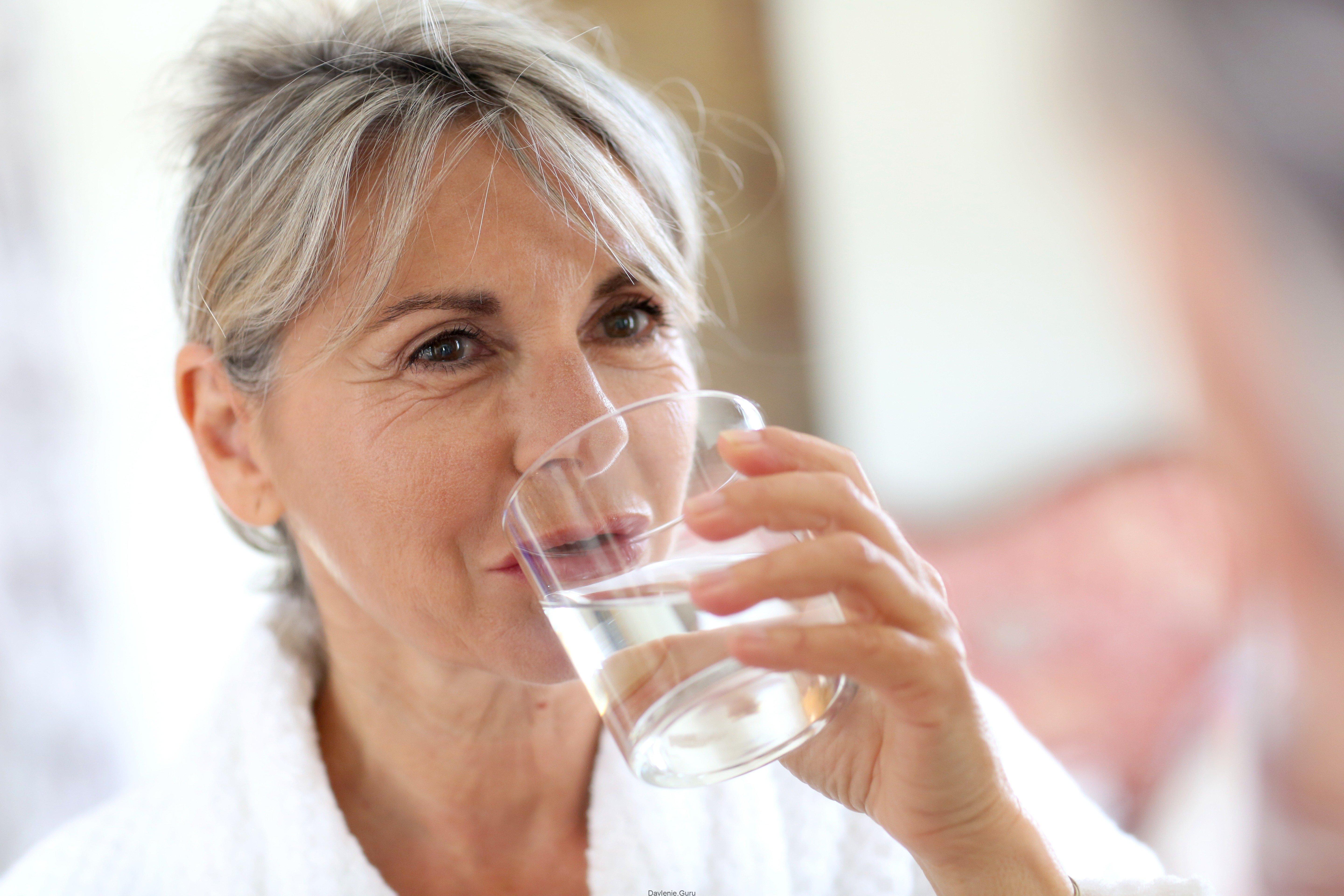 Пить воду пожилым. Женщина пьет воду. Женщина пьет воду из стакана. Пожилая женщина пьет из чашки. Пожилая женщина пьет воду.